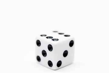 a plain white dice on white background in close up