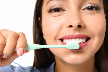 Beautiful woman brushing teeth on white background, closeup