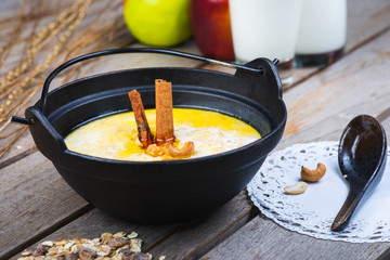 Traditional breakfast. Milk oatmeal with chocolate and granola. on a wooden table.