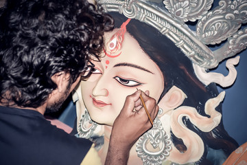 Painting the Eye over clay Idol of Hindu Goddess Durga. An idol making process of Pottery Artist at...