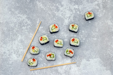 sushi rolls and sticks, grey background