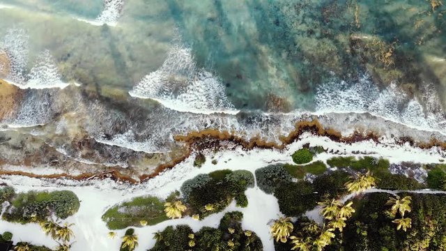 Aerial footage of the ocean and the beach in the Akumal Bay in Quintana Roo, Mexico during Sunset