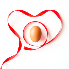 Healthy love food valentine day idea concept, Isolated gift of fresh chicken egg with red heart symbol ribbon decorated on white table background-top view(selective egg soft focus)
