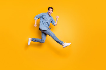 Fototapeta na wymiar Full length body size view of his he nice attractive cheerful cheery overjoyed guy jumping running having fun isolated over bright vivid shine vibrant yellow color background