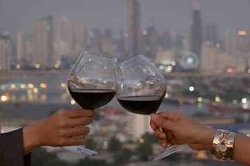  Romantic couple or friendship which happy moment relaxing ,red,wineglass,celebration on the rooftop in the night with bokeh background
