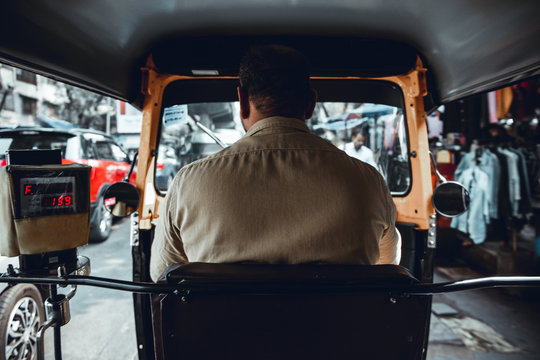Tuk tuk or rickshaw ride in India, Mumbai. Sitting behind the driver, looking at digital meter.