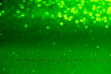 green Sparkling Lights Festive background with texture. Abstract Christmas twinkled bright bokeh...