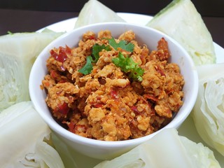 Thai food style, Selective focus of spicy Northern Thai pork with tomato and boiled cabbage in white bowl as a background, This food is most popular Thai food, Nam Prik Aong is Thai traditional