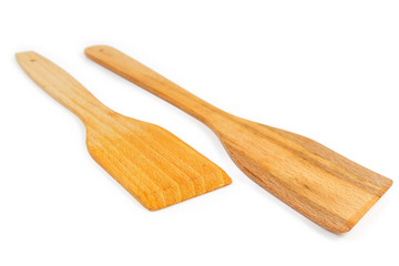 Two different wooden kitchen spatulas on white background close-up