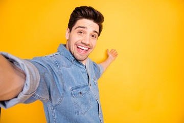 Photo of cheerful positive attractive man welcoming you to come to empty space behind him taking selfie isolated vivid color background