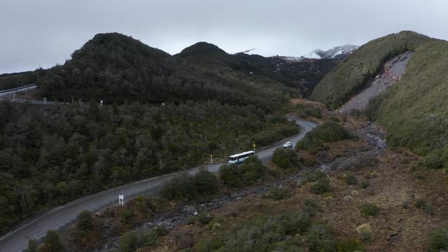 Following Bus Driving Through Mountains Wavy Road Clouds Snowy Mountain New Zealand 4K Expedition Aerial Flight Epic Mountain Range Beautiful Peak Winter Vacation Exploration Adventure Tourism Winter