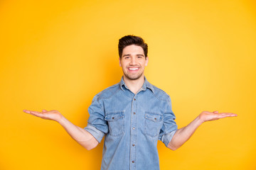 Photo of handsome attractive toothy beaming man showing you two objects to choose isolated vivid color background