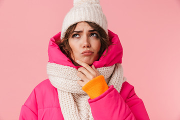 Portrait of beautiful perplexed woman in warm clothes looking upward
