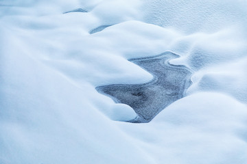 Frozen forest stream covered with snow. Image