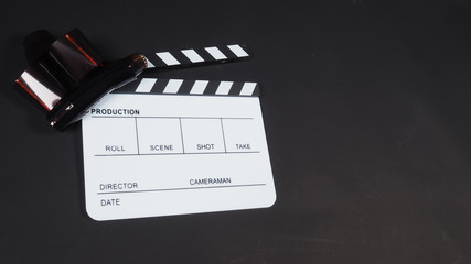Fototapeta na wymiar Film roll with Clapperboard or movie slate use in video production, cinema industry on black background.