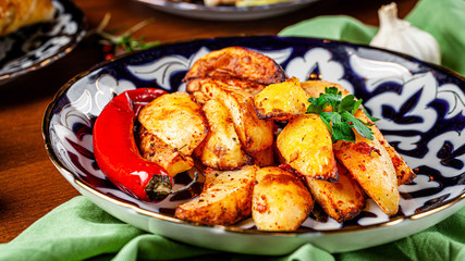 The concept of Uzbek cuisine. Different oriental dishes on the table in national Uzbek plates. Rustic fried potatoes. background image. copy space