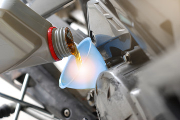 Refueling and pouring oil quality into the engine motorcycle Transmission and Maintenance Gear. Energy fuel concept.