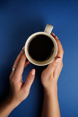 selective focus, female hands holding a mug of tea