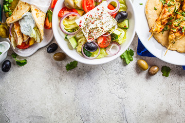 Greek food: greek salad, chicken souvlaki and gyro on gray background, top view, copy space....