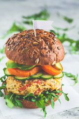 Vegan burger with vegetable cutlet, sweet potato, avocado, cucumber and arugula. Healthy plant...