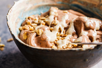 Vegan breakfast. Chocolate banana smoothie bowl with granola and nut butter.