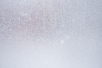 Ice and frost on a window pane in winter. Weather forecast: cold, frost, cooling. Abstract light...