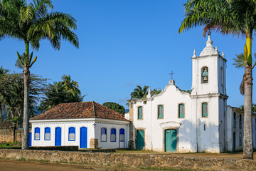 Fototapeta na wymiar Arial view of church Nossa Senhora das Dores (Our Lady of Sorrows) with palm trees on a sunny day, historic town Paraty, Brazil