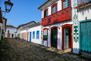 Typical cobblestone street with decorative and colorful colonial buildings in late afternoon light in historic town Paraty, Brazil
