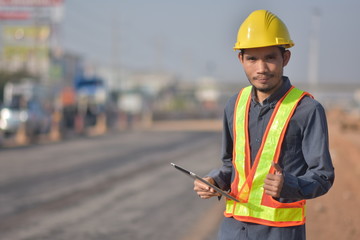 Engineering hold tablet is checking  surface of road in the road construction area. Land transportation system