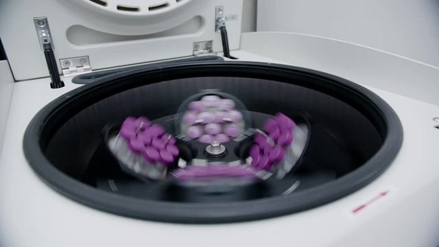 Close up of a medical lab centrifuge spinning test tubes. Lab test results