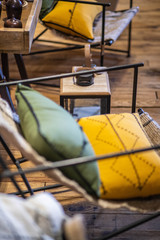 Chaise d&rsquo;int&eacute;rieur en acier noir avec des coussins et un sol en bois 