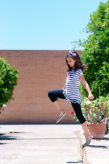 Happy girl jumping from a step in the street on a sunny day
