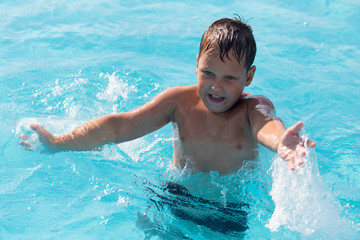 Fototapeta na wymiar The boy is swimming in the pool
