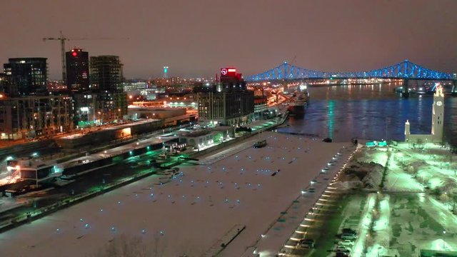 drone flying over the old port of montreal overloking the jacques carier bridge