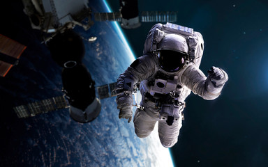 Astronaut at spacewalk with space station at background. Elements of this image furnished by NASA