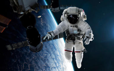 Astronaut repairs space station at Earth planet orbit. Elements of this image furnished by NASA