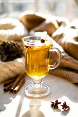 Hot winter drink with cinnamon and lemon on bright sunny day
