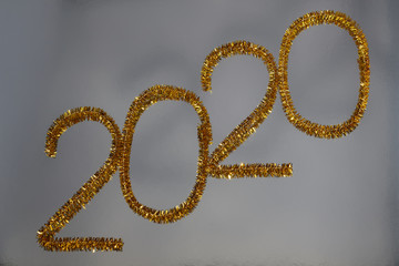 New year 2020 inscription made of glittering tinsel with a silver background.