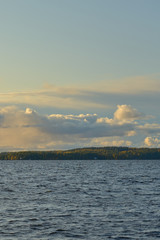 Rocks in the midle of a lake with cloudy sky and autumn forest on a background. Copy space.