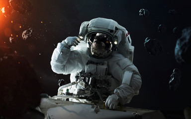 Obraz na płótnie Canvas Astronaut at spacewalk in asteroid field. Elements of this image furnished by NASA