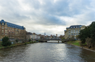 view of Strasbourg city with a tram crossing the Pont Royal Bridge over the canals