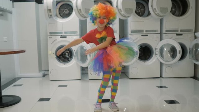 Happy Clown Little Girl Dancing And Have Fun In the Laundry Room. Little Child Clown Enjoying Dance, Having Fun Together, Party. Floss Dance Viral, Flossing. Slow motion.
