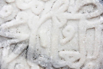 fragment of a gray stone wall depicting oriental patterns hieroglyphs