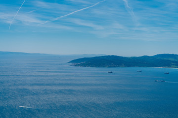 Seascape. Ocean rolling its waters evenly, islands, boats on the water and blue sky above them