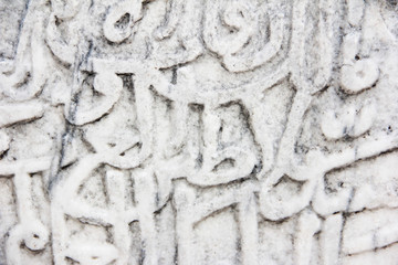 fragment of a gray stone wall depicting oriental patterns hieroglyphs