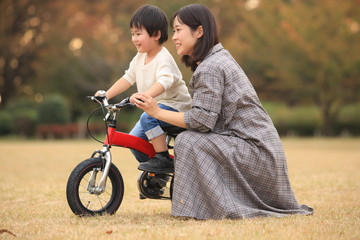 自転車に乗る練習をする親子