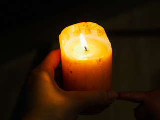 Candle in the hands on a dark background. during the festival of light