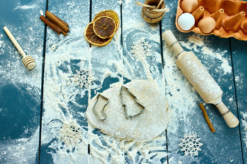 Christmas baking background. Raw dough for Christmas cookies. Kitchen utensils and ingredients for...