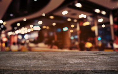 Empty dark wooden table in front of abstract blurred bokeh background of restaurant . can be used for display or montage your products.Mock up for space.