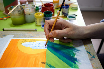 Close up of female painter hand painting with a brush painting acrylic paint